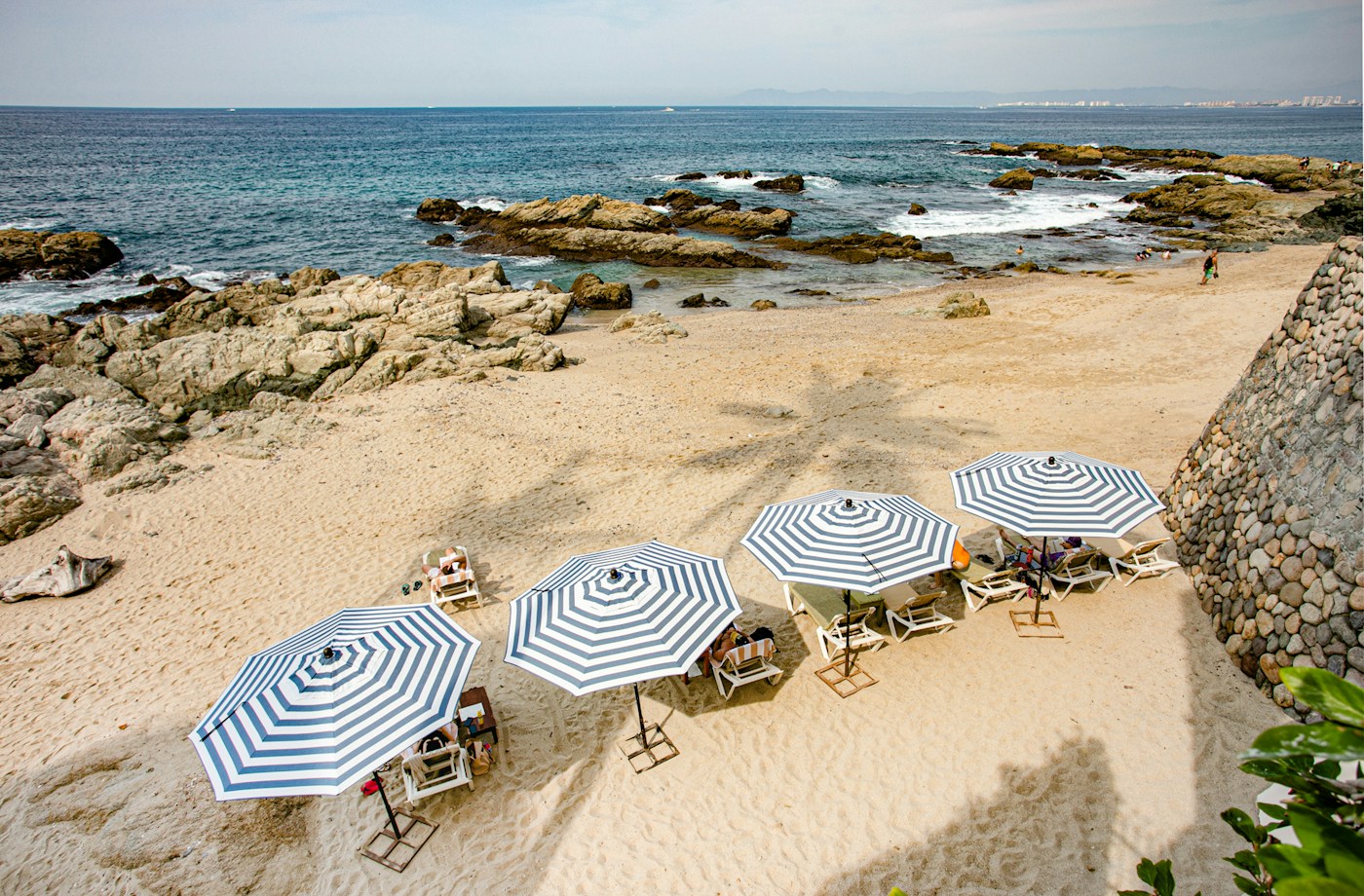The Pacific shoreline and beach umbrellas at Quinta Maria Cortez in Conchas Chinas
